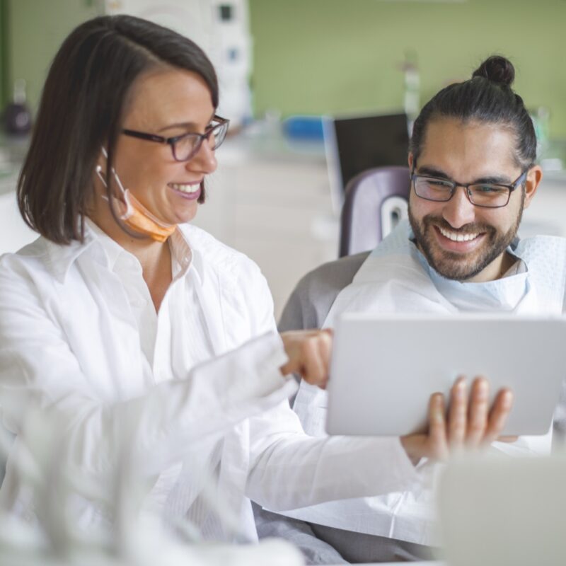 Denturist showing a digital scan to a patient